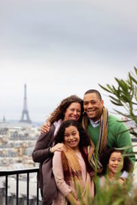 Family smiling in front of eiffel tower