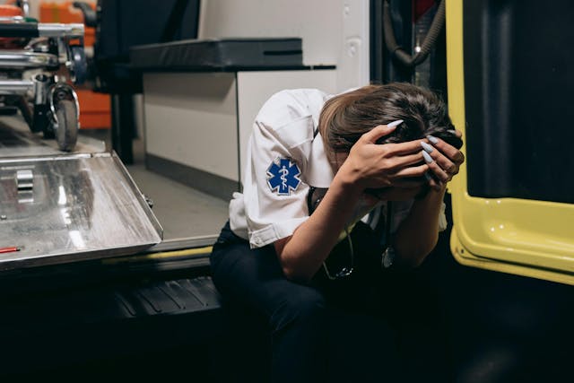 female paramedic with head in her hands