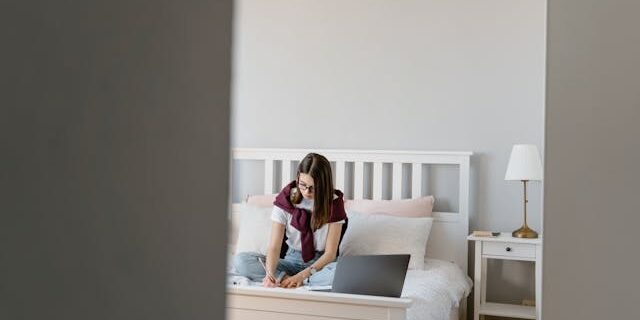 Girl doing homework on her bed