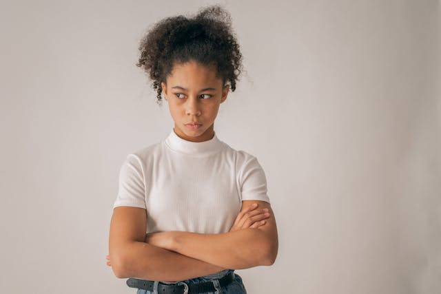 Teenage girl with arms folded looking disgusted