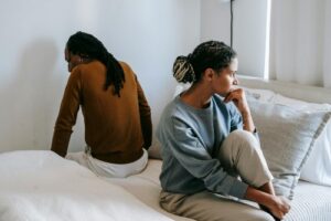 disconnected couple sitting on the bed